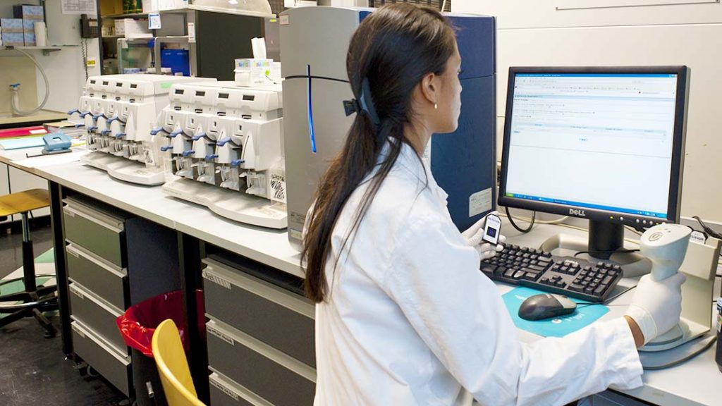Dans un laboratoire, chercheuse devant un écran d'ordinateur