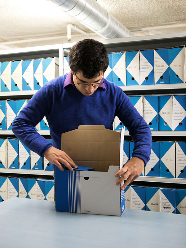 Un jeune archiviste reconditionne des documents 