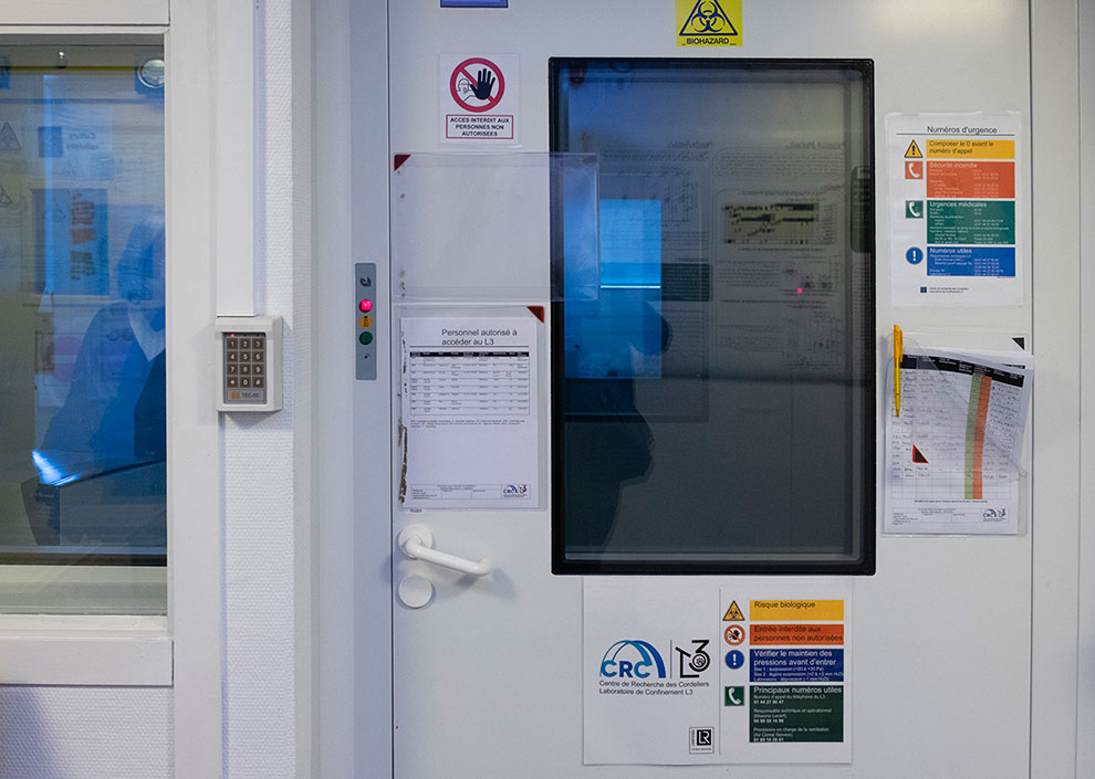 Dans un couloir, porte épaisse et vitrée avec digicode